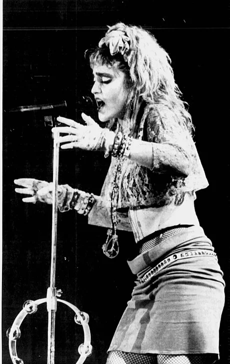 Madonna singing on stage in a lace top, 1985